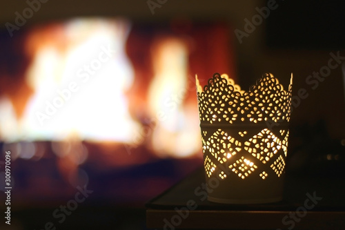 Candle holder in front of a fireplace at night. Selective focus.