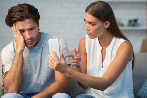 Photos Jealous Girlfriend Showing Boyfriend His Phone Sitting On Sofa Indoor