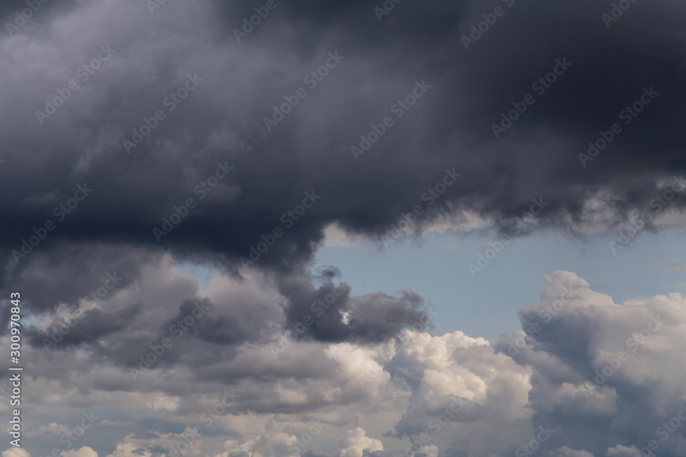 Cumulus fluffy white and dark grey storm clouds against blue sky background, heaven	