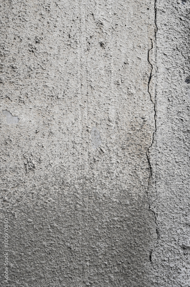 Cracked concrete grey wall covered with gray cement texture as background can be used in design. Dirty concrete texture with cracks and holes. Cracked concrete grey wall covered with gray cement texture as background can be used in design. Dirty concrete texture with cracks and holes.