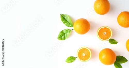 Oranges fruits composition with green leaves and slice on white wooden background, copy space.