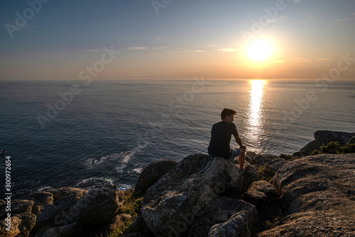 young boy relaxed in front of the sea in a sunset, holiday concept