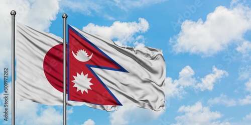 Japan and Nepal flag waving in the wind against white cloudy blue sky together. Diplomacy concept, international relations.
