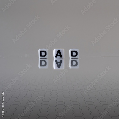 The concept of dad represented by black and white plastic letter cubes