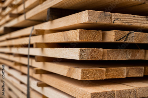 Piles of wooden boards in the sawmill, planking. Warehouse for sawing boards on a sawmill outdoors. Wood timber stack of wooden blanks construction material. Industry. photo