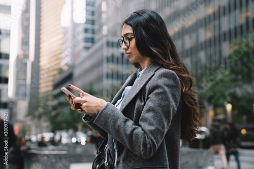 Canvas Print Beautiful young female using smartphone outside in New York City