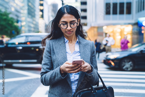 Canvas Print Young ethnic female using smartphone outdoors