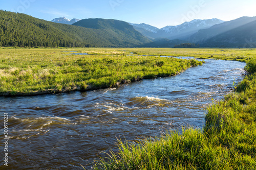 Spring Sunset at Big Thompson River - Evening sun shines on rushing Big Thompson River at Moraine Park in Rocky Mountain National Park, Colorado, USA.