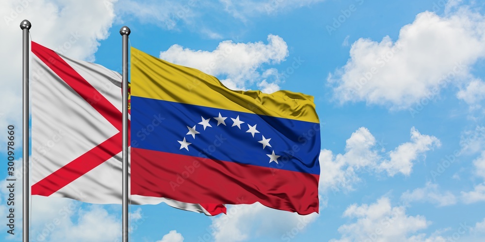 Jersey and Venezuela flag waving in the wind against white cloudy blue sky together. Diplomacy concept, international relations.