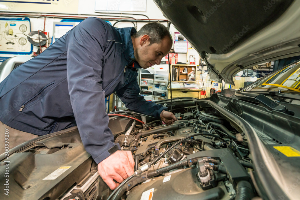 Auto mechanic working on car engine in mechanics garage. Car repair service. Auto mechanic working on car engine in mechanics garage. Car repair service.