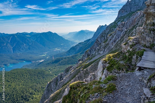 Alpine lake with mountain range and forest landscape on sunny summer day