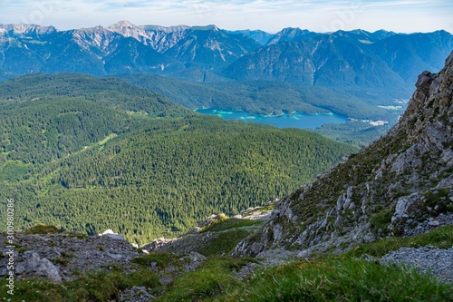 Alpine lake with mountain range and forest landscape on sunny summer day