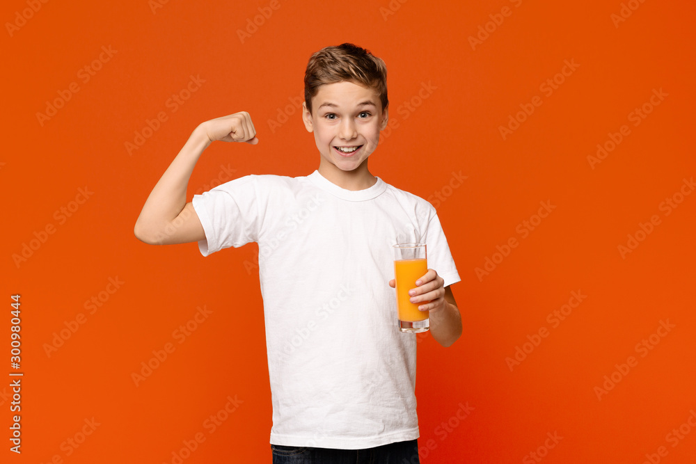 Confident teenager with orange juice showing strong biceps Confident teenager with orange juice showing strong biceps