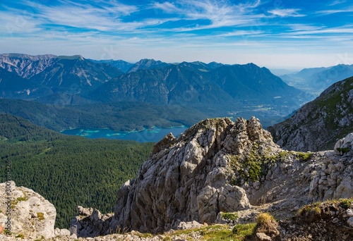 Alpine lake with mountain range and forest landscape on sunny summer day
