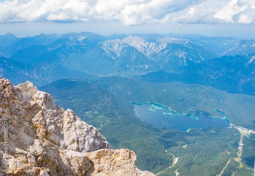 Alpine lake with mountain range and forest landscape on sunny summer day