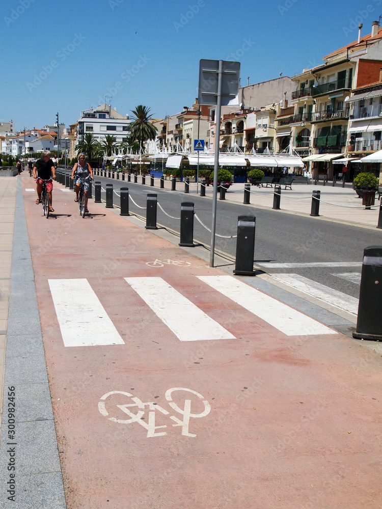 Cambrils, the city embankment with a dedicated bike path separated from the roadway by a fence.