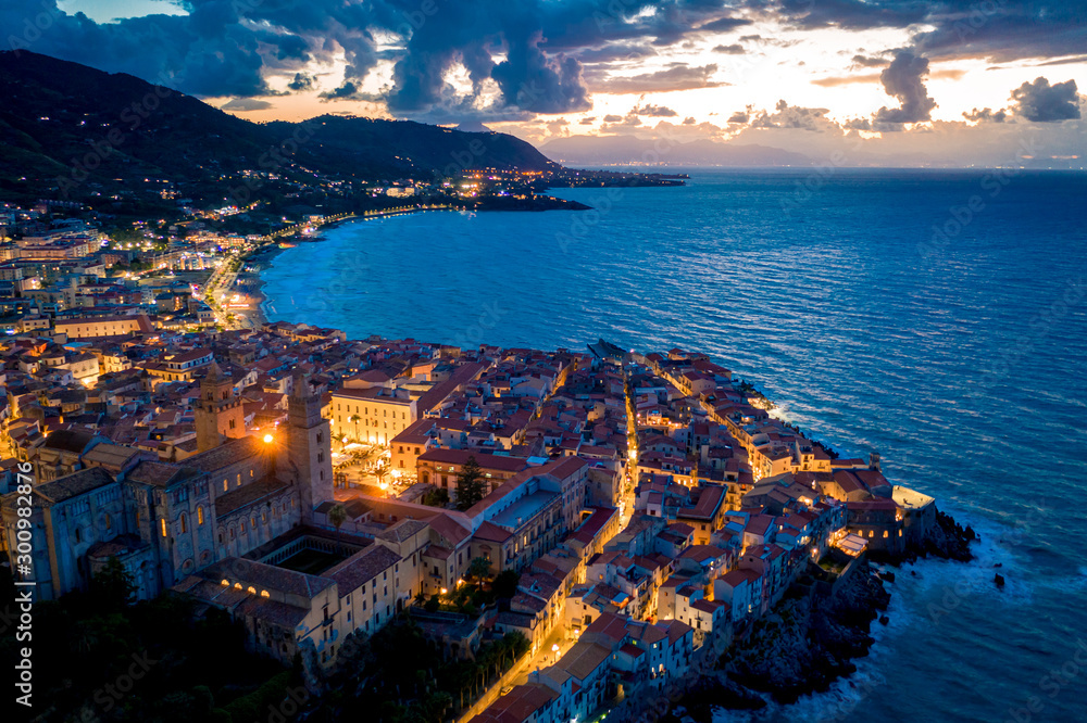 Cefalu Sicily night town aerial view with the city lights and sunset sky . Italy, Tyrrhenian Sea