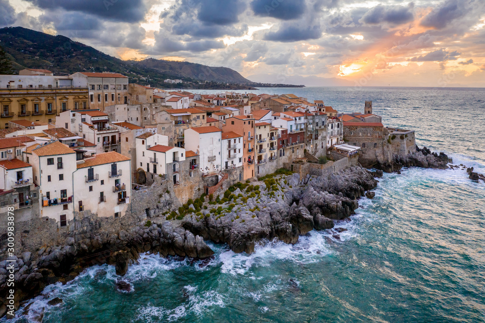 aerial view with the city lights and sunset sky . Italy, Tyrrhenian SeaView of the coastal houses of Cefalu from the Tyrrhenian Sea at sunset, Sicily, Italy
