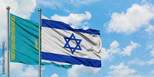 Kazakhstan and Israel flag waving in the wind against white cloudy blue sky together. Diplomacy concept, international relations.