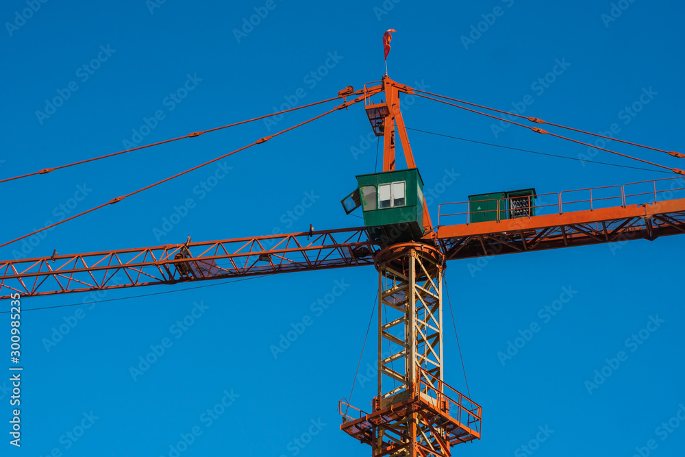 Tower crane against blue sky on a construction site for building of multi storage building or another type of structure. Tower crane against blue sky on a construction site for building of multi storage building or another type of structure.
