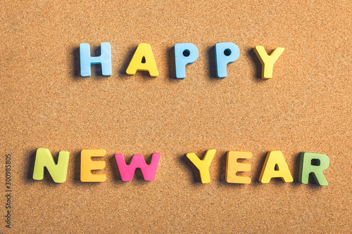 Happy New Year word formed by letter pieces on cork background