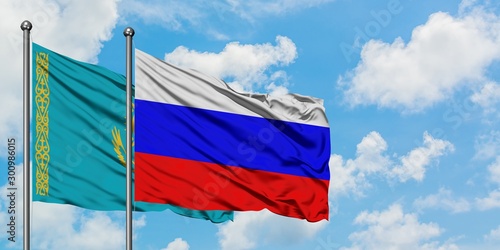 Kazakhstan and Russia flag waving in the wind against white cloudy blue sky together. Diplomacy concept, international relations.