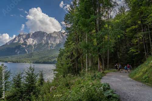 Alpine lake with mountain range and forest landscape on sunny summer day