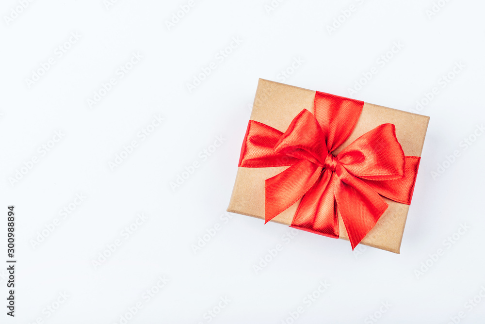 Cardboard gift box with red bow on white background. Flat lay. Top view. Copy space for your text. Cardboard gift box with red bow on white background. Flat lay. Top view. Copy space for your text.