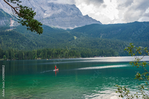 Alpine lake with mountain range and forest landscape on sunny summer day