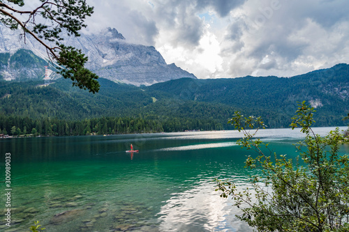 Alpine lake with mountain range and forest landscape on sunny summer day