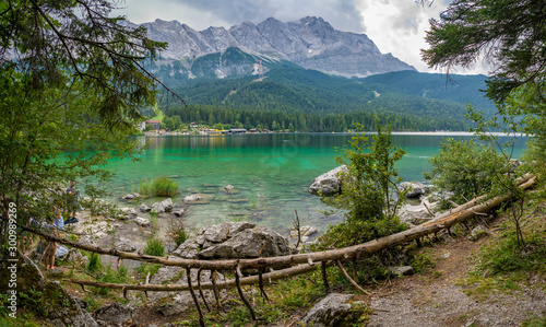 Alpine lake with mountain range and forest landscape on sunny summer day