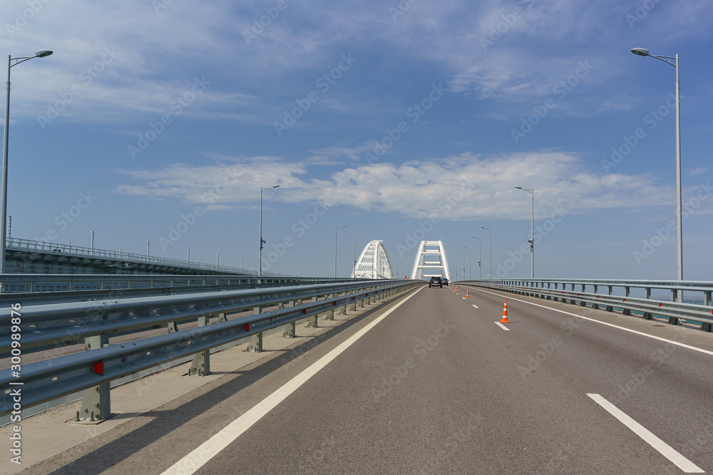 Automotive orange cones narrowing the road due to maintenance repairs. Crimean bridge . In front of the arched span