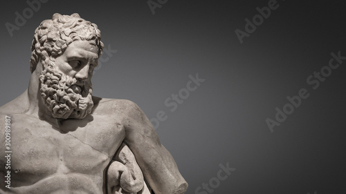 Banner with statue of powerful and handsome bearded Hercules at smooth gradient grey background and paste space, closeup, details