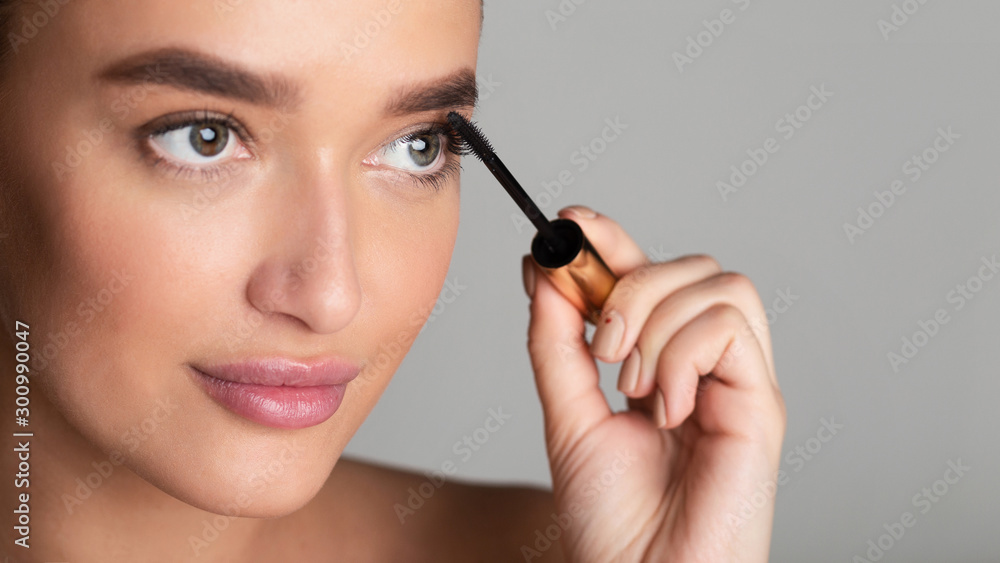 Beauty concept. Lady applying black mascara on eyelashes