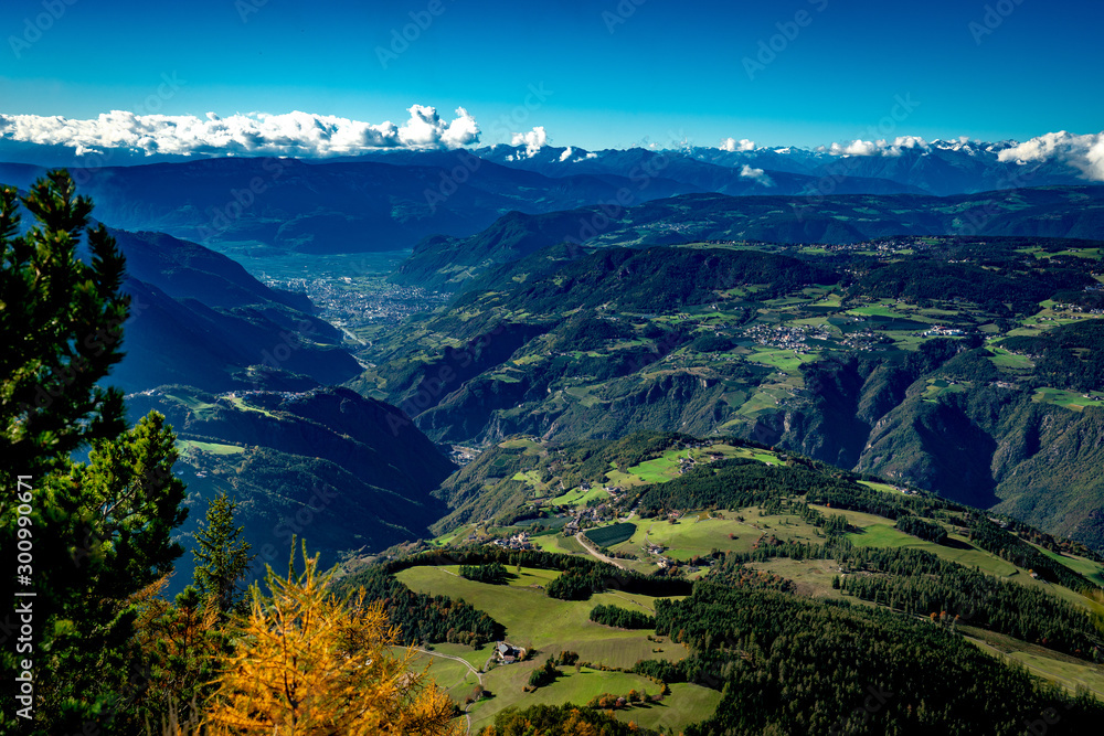 View from the Voelsegg mountain south overlooking Proesels and Oberaicha village to the  Eisacktal valley and the town Bozen on a bright autumn day with Unterinn and Oberbozen in the background - obrazy, fototapety, plakaty 