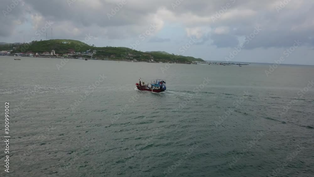 A flying camera takes a fishing boat floating on the sea overlooking the islands. In vietnam A flying camera takes a fishing boat floating on the sea overlooking the islands. In vietnam