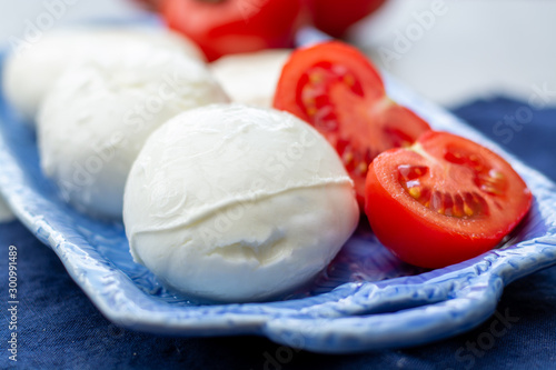 Cheese collection, fresh Italian soft mozzarella cheese in balls served with red ripe tomatoes