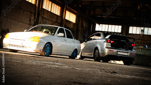 Two cars in an abandoned hangar.