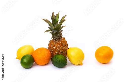 Pineapple with lemon and lime and oranges on a white background. Group of citrus fruits close-up. Lime green  pineapple  orange orange  lemon close-up on an isolated white background.