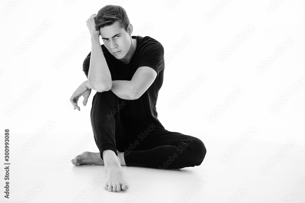 Fototapeta premium Black and White Muscle strong beautiful stripped male model in denim jeans and black t-shirt with belt on white isolated font background