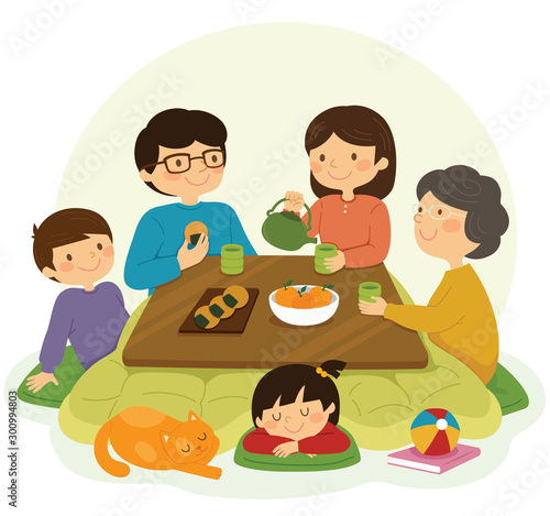 Japanese family sitting around the kotatsu table and drinking tea.