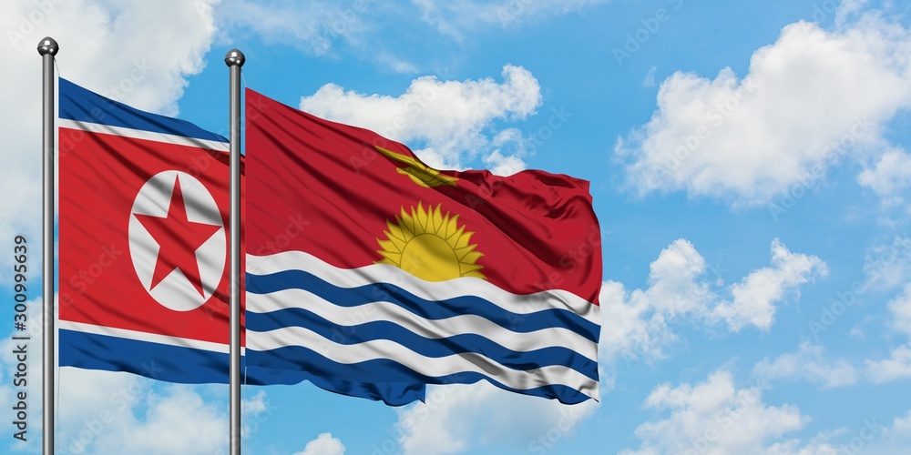 North Korea and Kiribati flag waving in the wind against white cloudy blue sky together. Diplomacy concept, international relations.