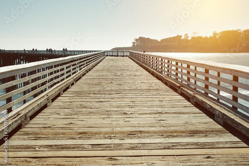 Old wood pier illuminated by warm lighting in the Pacific Ocean