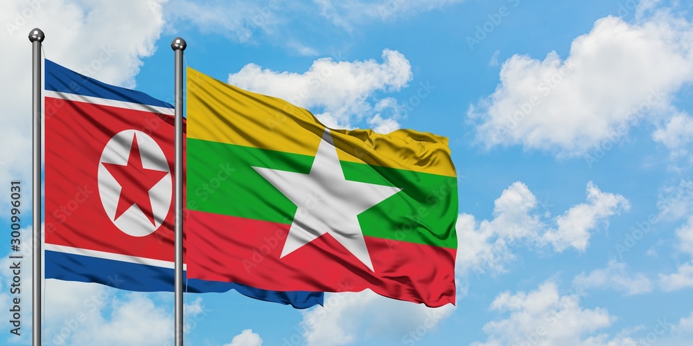 North Korea and Myanmar flag waving in the wind against white cloudy blue sky together. Diplomacy concept, international relations. North Korea and Myanmar flag waving in the wind against white cloudy blue sky together. Diplomacy concept, international relations.