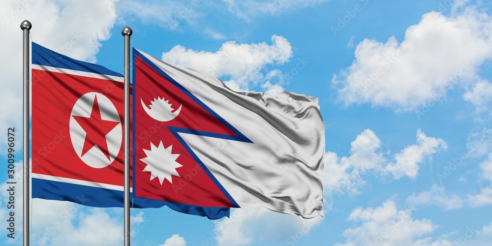 North Korea and Nepal flag waving in the wind against white cloudy blue sky together. Diplomacy concept, international relations.