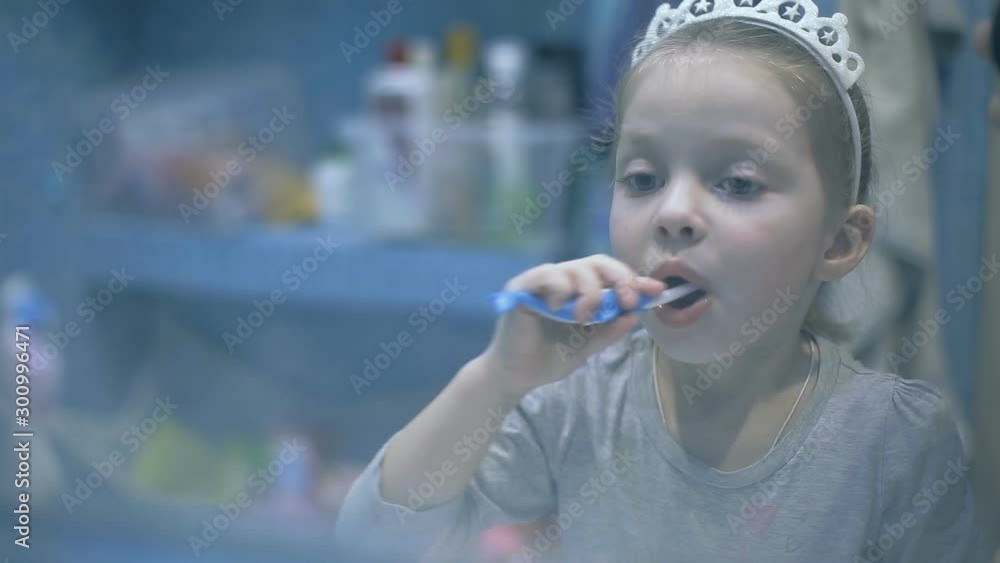 Little girl f brushing her teeth with a toothbrush in bathroom in the morning. Little girl f brushing her teeth with a toothbrush in bathroom in the morning.