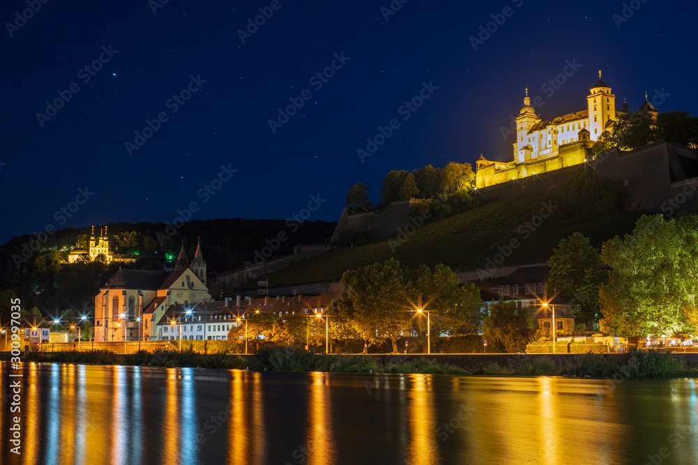 Die Festung Marienburg und die Wallfahrtskirche Käppele in Würzburg bei Nacht mit Spiegelungen im Main