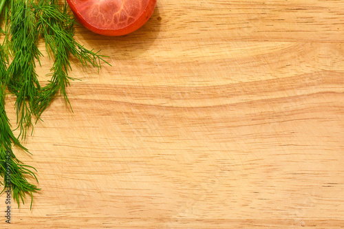 wooden cutting board with dill and tomatoes