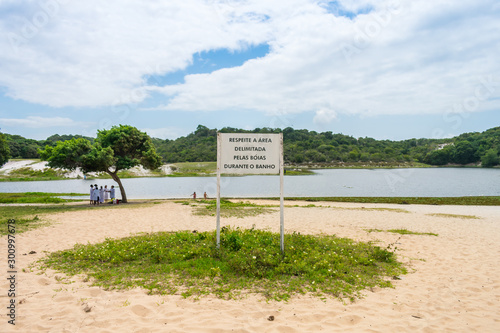 Salvador, Brazil - Circa September 2019: Warning sign saying to respect the swimming area limits at Abaete Lagoon, famous landmark of Itapua neighborhood in Salvador, Bahia photo