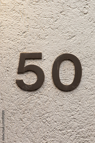 brass number 50 on white wall